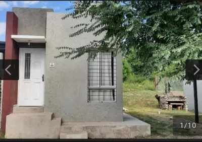 a house with a white door and a tree at San Antonio de Arredondo in San Antonio de Arredondo