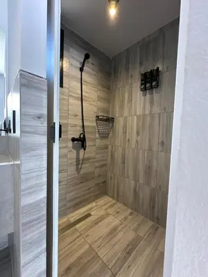 a bathroom with a shower with a wooden wall at BoxPoint MotoResort in Cordoba