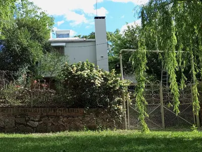 a house with a fence in front of a yard at Casa Cali in Tanti Nuevo