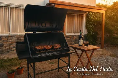 a grill with chickens cooking on it next to a table at La Casita del Hada in Santa María