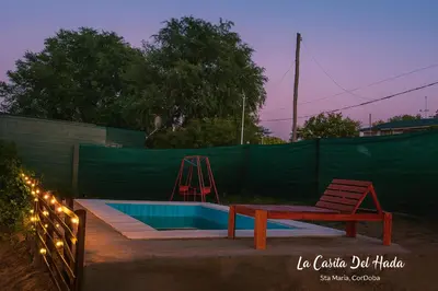 a bench next to a swimming pool with a swing at La Casita del Hada in Santa María