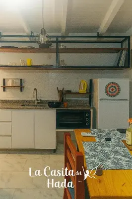 a kitchen with a table and a kitchen with a refrigerator at La Casita del Hada in Santa María