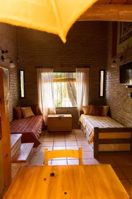 a large room with two beds and a table at Casa de Campo in Santa Rosa de Calamuchita