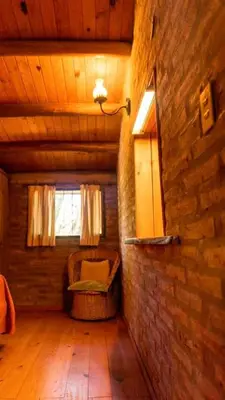 an attic room with a chair and a window at Casa de Campo in Santa Rosa de Calamuchita