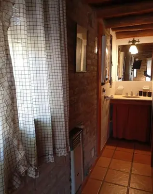 a bathroom with a sink and a brick wall at Casa de Campo in Santa Rosa de Calamuchita