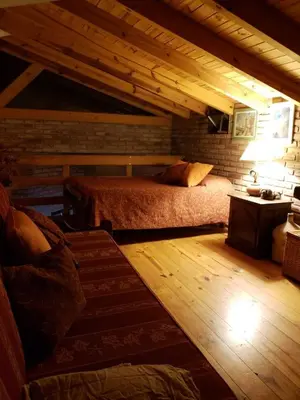 a attic bedroom with two beds and a table at Casa de Campo in Santa Rosa de Calamuchita