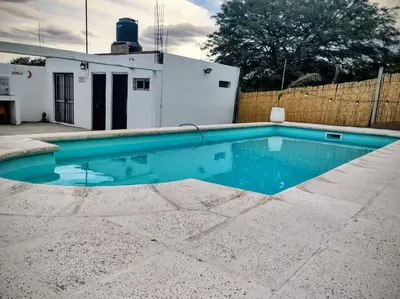 a swimming pool with blue water in a yard at Estación La Perla in Alta Gracia