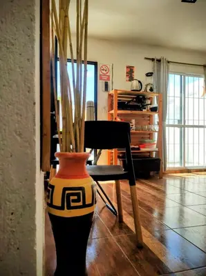 a vase sitting next to a chair in a room at Estación La Perla in Alta Gracia