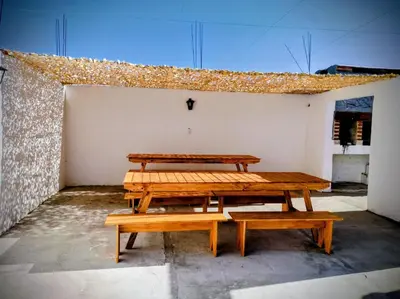 two picnic tables in a room with a wall at Estación La Perla in Alta Gracia