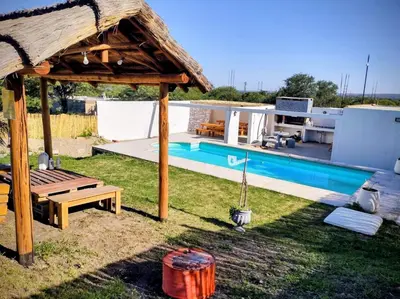 a villa with a swimming pool and a house at Estación La Perla in Alta Gracia