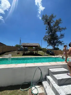 a swimming pool with a hose next to a picnic table at Estación La Perla in Alta Gracia