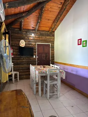 a dining room with a table and chairs in a cabin at Cabañas La Lila in Santa Rosa de Calamuchita
