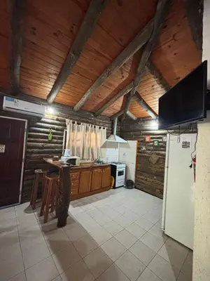 a kitchen with a refrigerator and a stove top oven at Cabañas La Lila in Santa Rosa de Calamuchita
