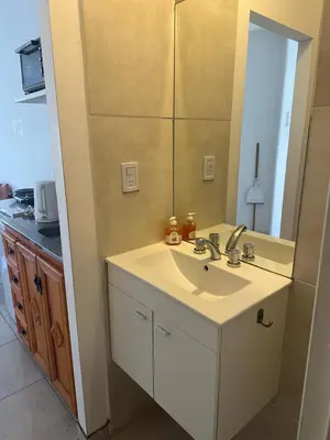 a bathroom with a sink and a mirror at Quetzal Apart Central Apartment N 3 in Villa Carlos Paz