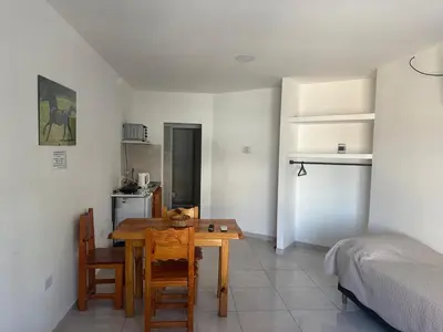 a room with a table and a bedroom with a bed at Quetzal Apart Central Apartment N 3 in Villa Carlos Paz