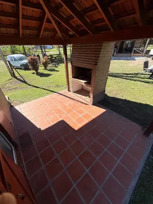 an outdoor patio with a brick floor and a fireplace at Cabañas Lomas del mirador in Villa del Dique
