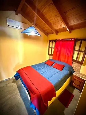 a bedroom with a bed with a red and blue blanket at Koonex in Los Reartes