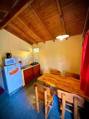a kitchen with a wooden table and a white refrigerator at Koonex in Los Reartes