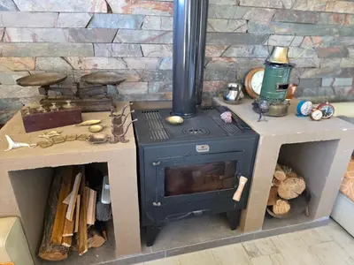 a blue stove with two tables and a brick wall at havendq in Villa General Belgrano