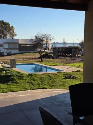 a swimming pool in a field with a building in the background at havendq in Villa General Belgrano
