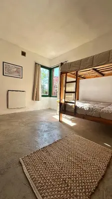 a room with two bunk beds and a rug at La Colorada de Yacanto in Villa Yacanto