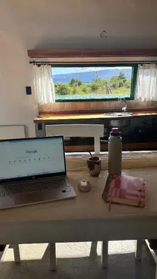 a laptop computer sitting on a table in front of a window at La Colorada de Yacanto in Villa Yacanto