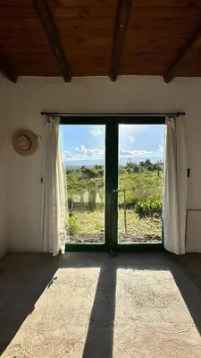 a room with a window with a view of a field at La Colorada de Yacanto in Villa Yacanto