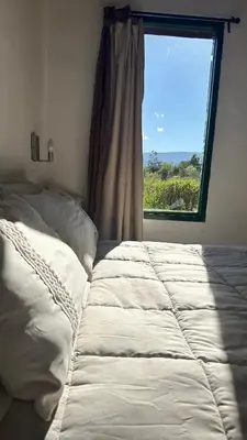 a bed in a bedroom with a window at La Colorada de Yacanto in Villa Yacanto