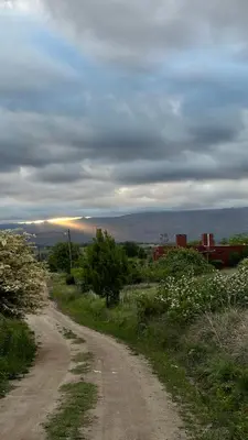 a dirt road on a hill with a cloudy at La Colorada de Yacanto in Villa Yacanto