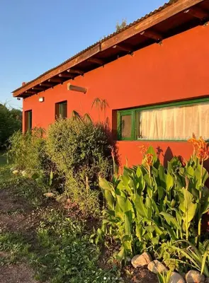 a red house with plants in front of it at La Colorada de Yacanto in Villa Yacanto