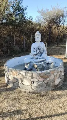 a statue of aitatingitating woman sitting in a fountain at Antar Mouna in Cortaderas