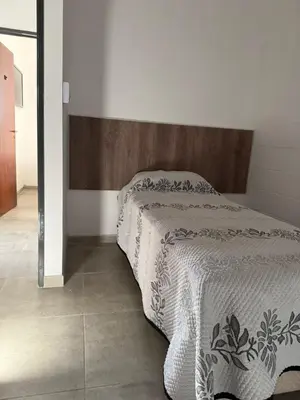a bedroom with a bed with a wooden headboard at La Rosas apartments in La Porteña