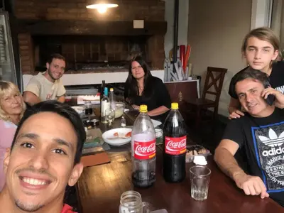 a group of people sitting around a table with cocacola bottles at La Rosas apartments in La Porteña