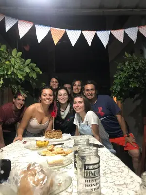 a group of people posing for a picture at a table at La Rosas apartments in La Porteña
