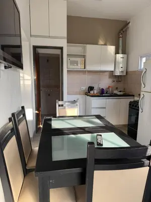 a small kitchen with a table and chairs in it at La Rosas apartments in La Porteña