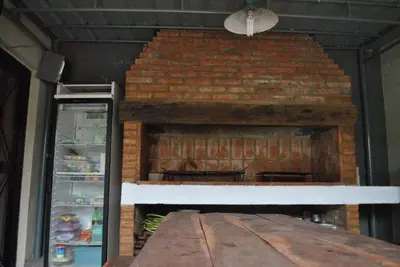 a brick fireplace in a room with a refrigerator at La Rosas apartments in La Porteña