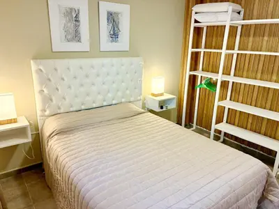 a bedroom with a white bed and two shelves at Complejo Baren in Villa Ciudad Parque