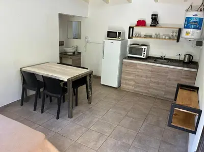 a kitchen with a table and a white refrigerator at Complejo Baren in Villa Ciudad Parque