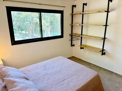 a bedroom with a bed and a window and shelves at Complejo Baren in Villa Ciudad Parque