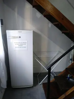 a small white refrigerator sitting next to a staircase at Alojamiento Libertador in Alta Gracia