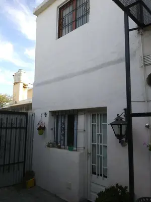 a white house with a door and a window at Alojamiento Libertador in Alta Gracia