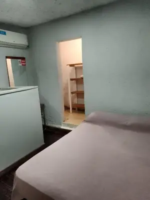 a room with a bed and a room with a refrigerator at Alojamiento Libertador in Alta Gracia