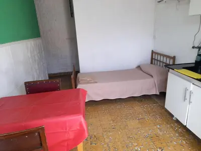 a small room with a small bed and a table at Departamento por dia in Río Cuarto