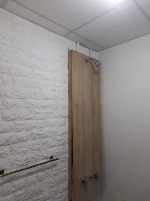 a room with a wooden door and a white wall at Departamento por dia in Río Cuarto