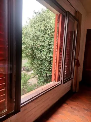 an open window with a view of a bush at Casa Centrica Mina Clavero in Mina Clavero