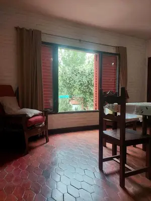 a living room with a large window and a chair at Casa Centrica Mina Clavero in Mina Clavero