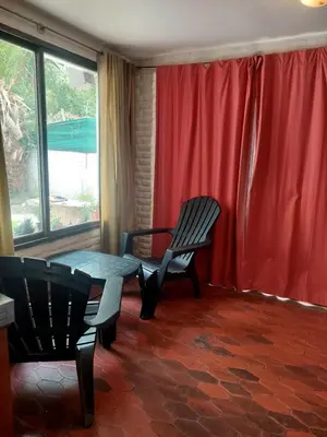 a room with a table and chairs and a red curtain at Casa Centrica Mina Clavero in Mina Clavero