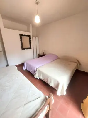 a bedroom with two beds and a mirror on the wall at Casa Centrica Mina Clavero in Mina Clavero