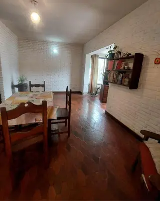a living room with a table and chairs and a brick wall at Casa Centrica Mina Clavero in Mina Clavero