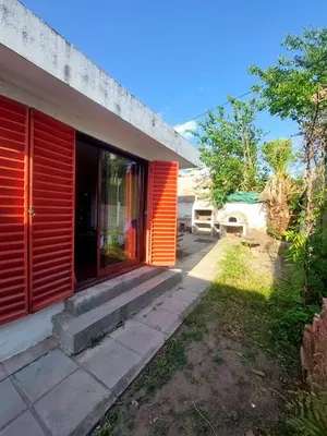 a house with red shutters on the side of it at Casa Centrica Mina Clavero in Mina Clavero
